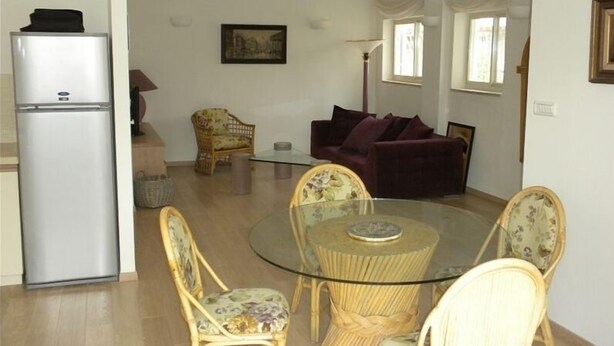 A living room with a round glass table, wicker chairs, a purple sofa, and a white ceiling light. - Gorgeous 2.5 Bdrm Apt. in Jerusalem (Jerusalem)