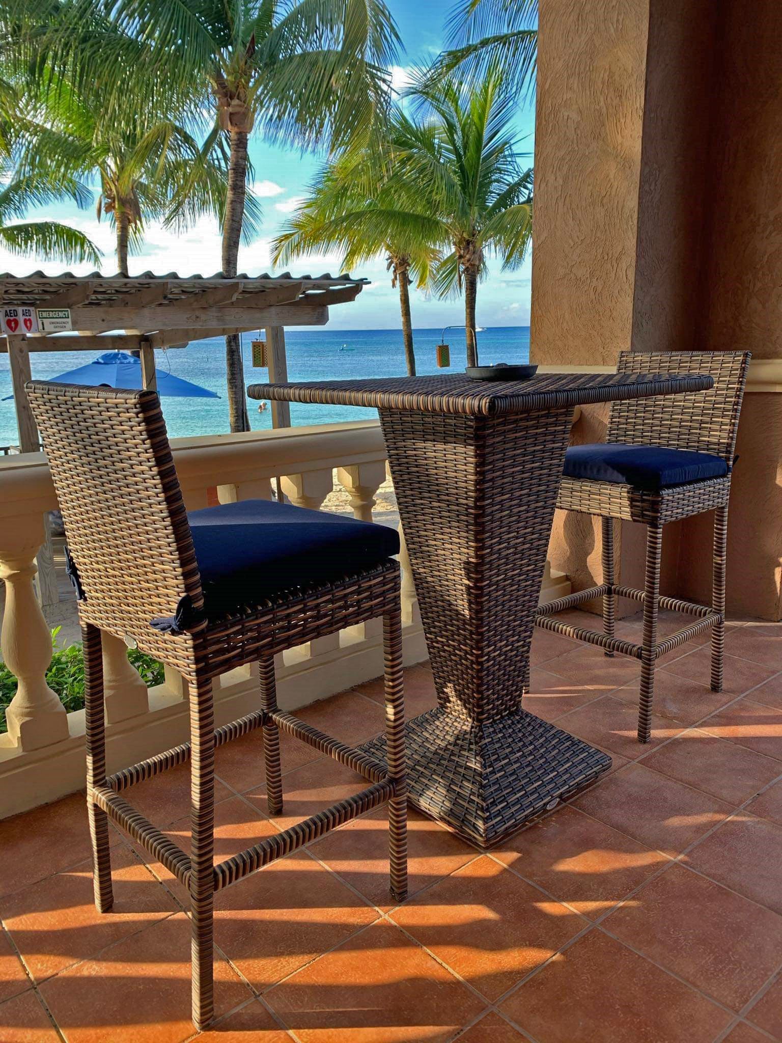 A wicker outdoor seating area with a view of the ocean.