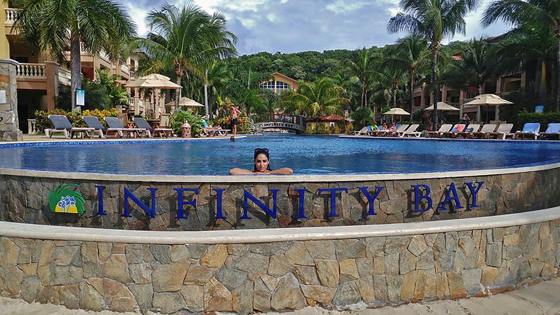 Ein Poolbereich mit einem Schild, auf dem 'INFINITY BAY' steht.