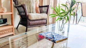 A glass-top table with a woven mat, a small plant, and a book. - Work remote, or not at all, in paradise at this cozy, beachy condo!  (Tavernier)