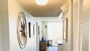 A hallway with a ceiling fan, a decorative wall piece, and a view to a balcony. - Work remote, or not at all, in paradise at this cozy, beachy condo!  (Tavernier)
