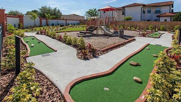 A residential area with a playground, a small pool, and a house with a red roof. - Spacious, Private Pool/Spa, Nice View, Game Rm, Next to Clubhouse, Gated Resort (Clermont)
