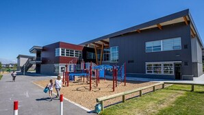 A modern building with a playground in front. - Self Entrance 2 BR, Whole Suite, Close To White Rock Beach & US Border, NEW (Surrey)
