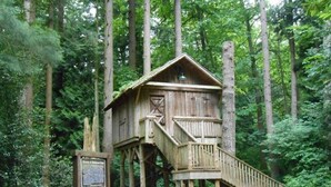 A wooden cabin with a staircase leading up to a platform, surrounded by trees. - Self Entrance 2 BR, Whole Suite, Close To White Rock Beach & US Border, NEW (Surrey)