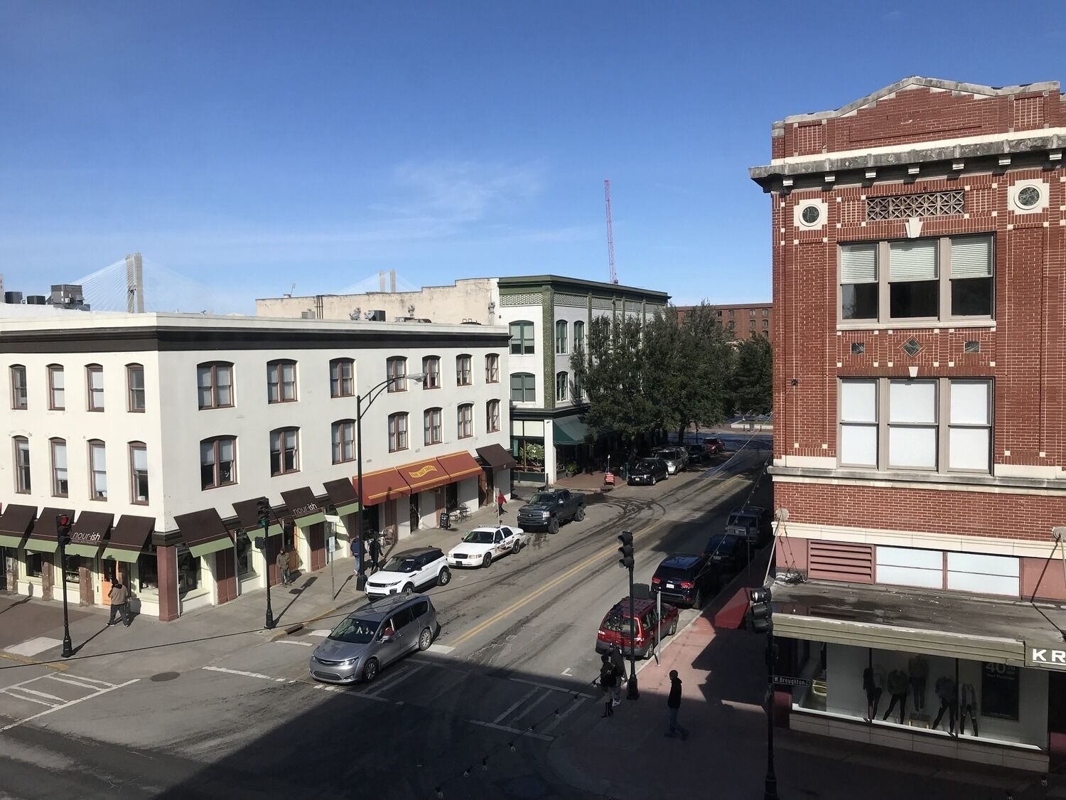 A street view with buildings, cars, and pedestrians.