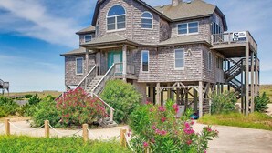 A two-story wooden house with a balcony and a staircase leading to the second floor.