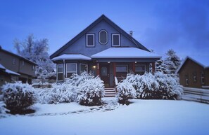Ein Haus mit schneebedecktem Dach und Vorgarten, umgeben von weiteren Häusern.