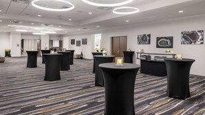 A conference room with round tables, black tablecloths, and a carpeted floor. - Hilton Garden Inn Denver/Thornton (Thornton)