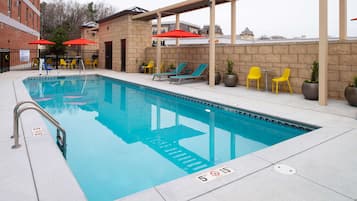 Una piscina al aire libre de temporada, sombrillas