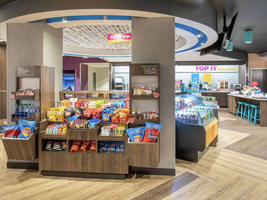 A snack display area with various packaged snacks and a beverage dispenser.