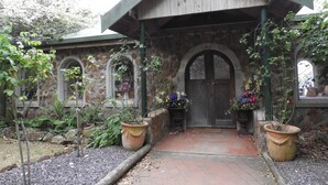 Un edificio rústico de piedra con entrada de madera y ventanas de arco.