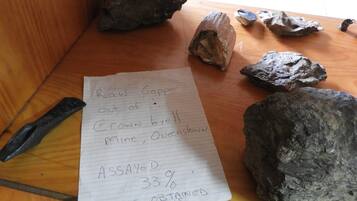 A handwritten note on a piece of paper with text and a list of rocks on a wooden surface.
