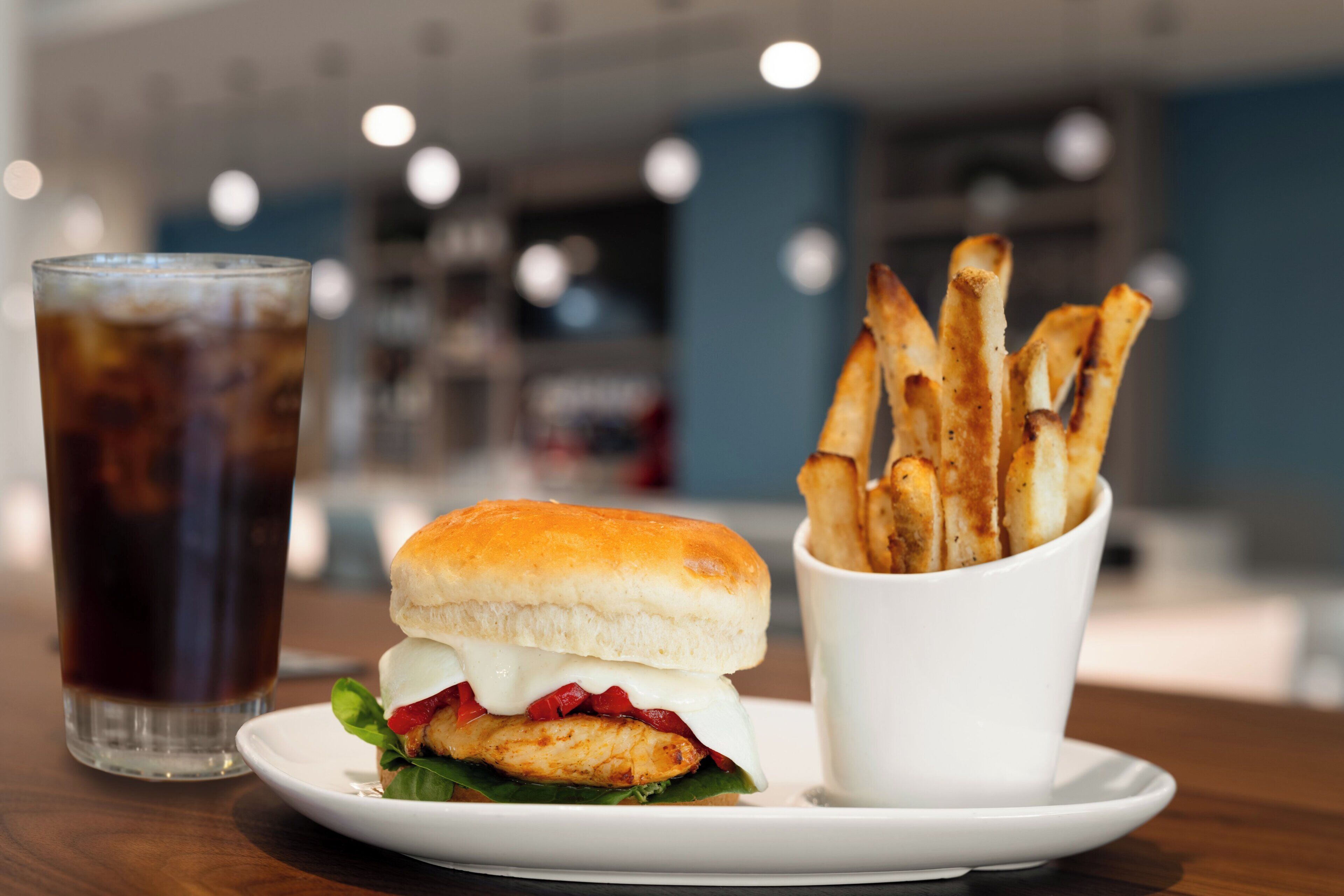 A meal consisting of a sandwich, fries, and a drink on a plate.