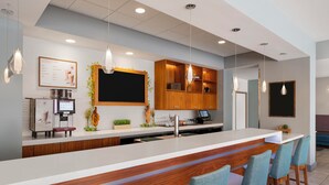 Une cuisine moderne avec un coin bar, des meubles en bois et des tabourets de bar.