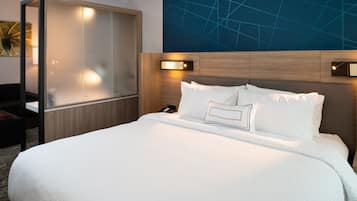 Una habitación de hotel con una cama grande, cabecera de madera y una lámpara fijada a la pared.