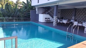 A swimming pool with a sun deck area, a staircase, and outdoor seating. - River Vally Inn (Pathahewaheta)