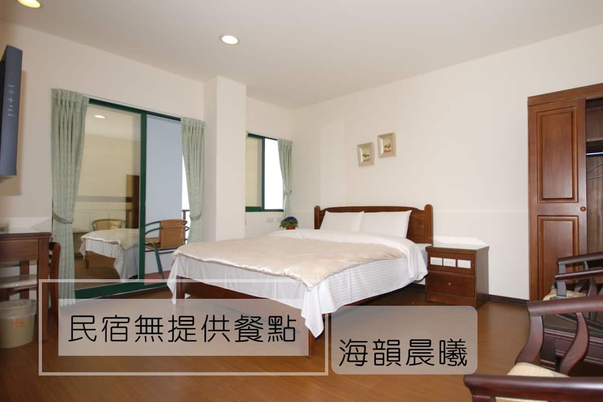 Una habitación de hotel con una cama, un armario de madera, un escritorio y una silla.