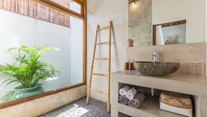 A bathroom with a large window, a wooden ladder, a stone sink, and a potted plant. - Eco Chic 5BDR Oberoi/ Central Seminyak/beach (Seminyak)