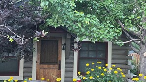 A wooden cabin with a front door, windows, and a wreath on the door.