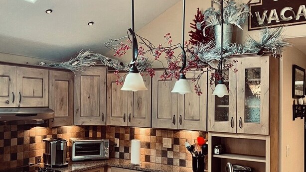 A kitchen with wooden cabinets, a microwave, a toaster, and a sink.