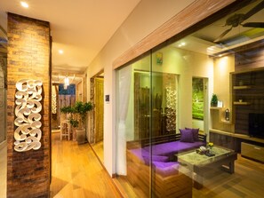 Relax in a comfortable seating area with a sofa and coffee table, surrounded by decorative elements and soft lighting.