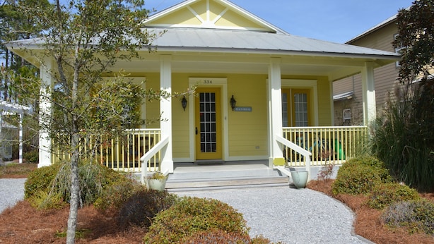 A yellow building with a porch, a door labeled "334", and a sign that says "Beach House".