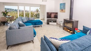 Uma sala de estar moderna com um conjunto de sofá, uma televisão e uma lareira a lenha.