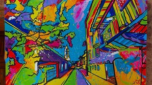 Un cuadro abstracto y colorido en una pared sobre un mueble de madera con una radio Corona.
