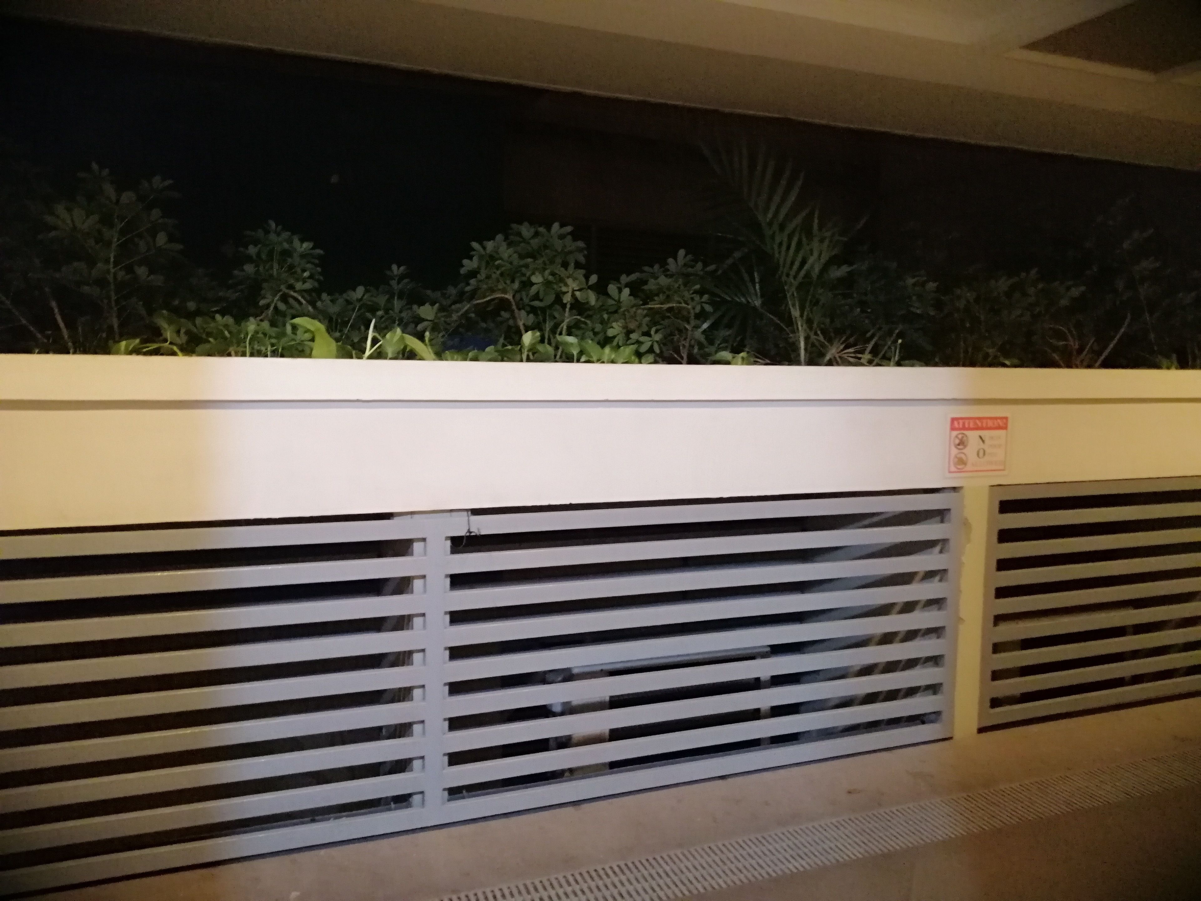 A white wall with horizontal slats and a sign indicating no smoking.
