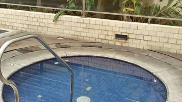 Enjoy a refreshing swim in the pool surrounded by lush greenery and a serene atmosphere.