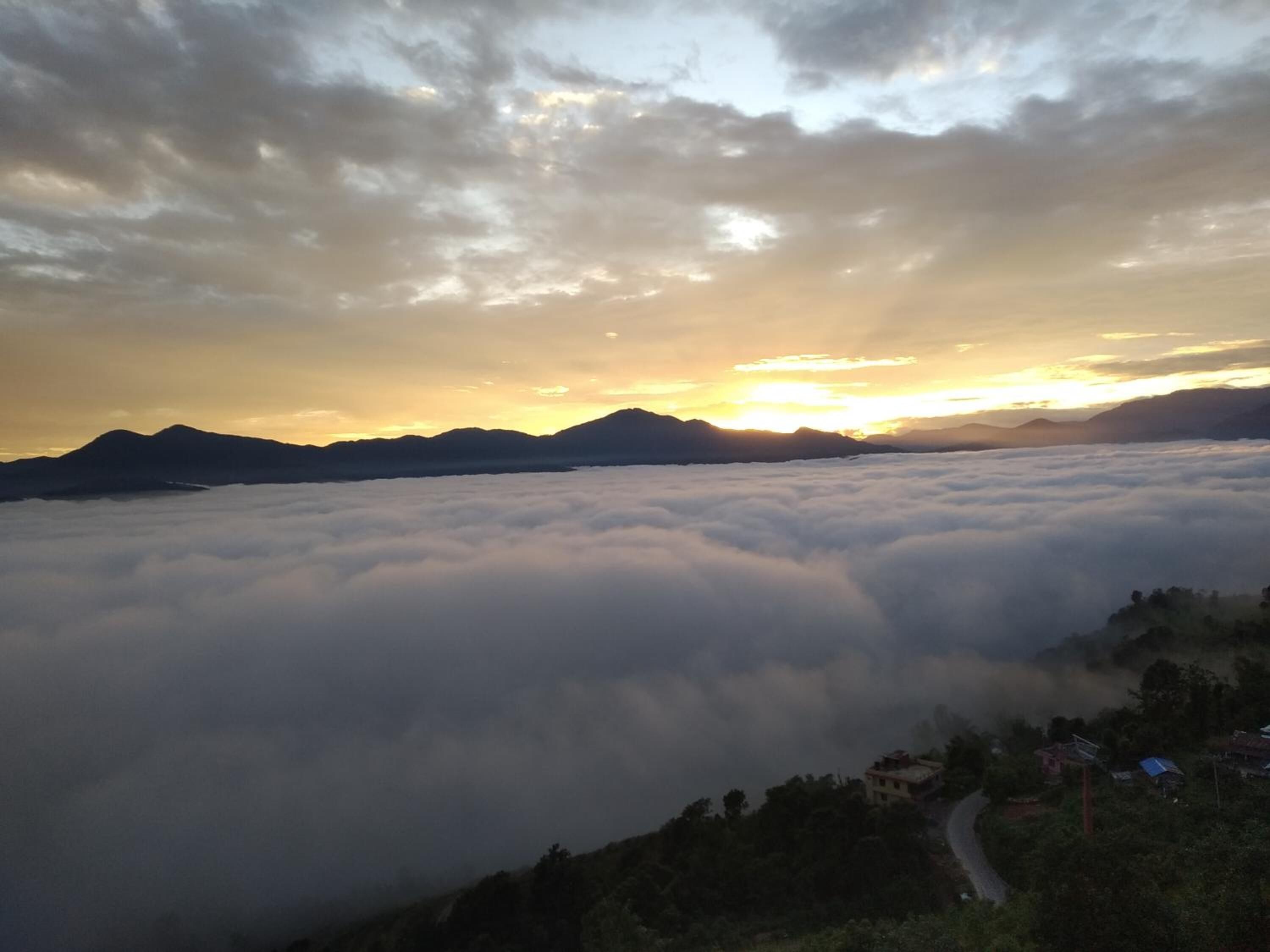 A mountainous landscape with a valley of clouds at sunrise or sunset.