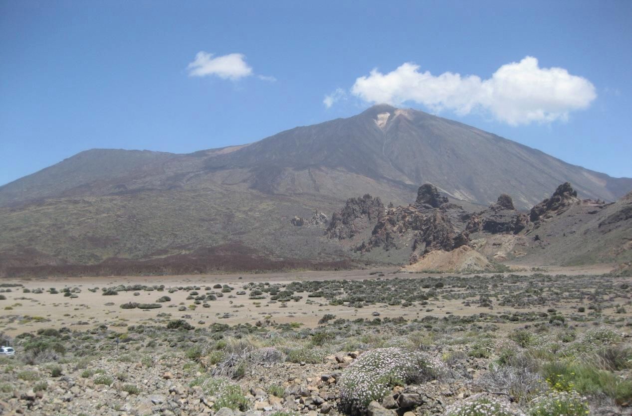Un paysage montagneux caractérisé par un sommet imposant et une végétation clairsemée.