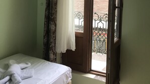 A room with a bed, a window with an open door, and a view of the outside balcony. - Historial Hotel (Istanbul)