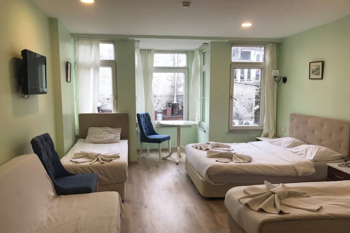 A hotel room with two beds, a desk, and a chair.