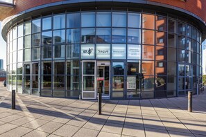 A modern building with large glass windows, a sign for 'Sagye Restaurant,' and a clear entrance.