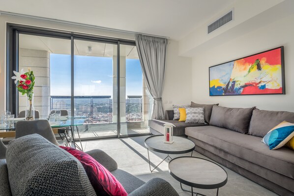A modern living room with a sofa, coffee table, and a dining area with a glass table.