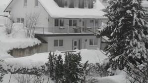 A two-story house with a snow-covered roof and a balcony. - Ferienwohnung van Balkom (Schmallenberg)