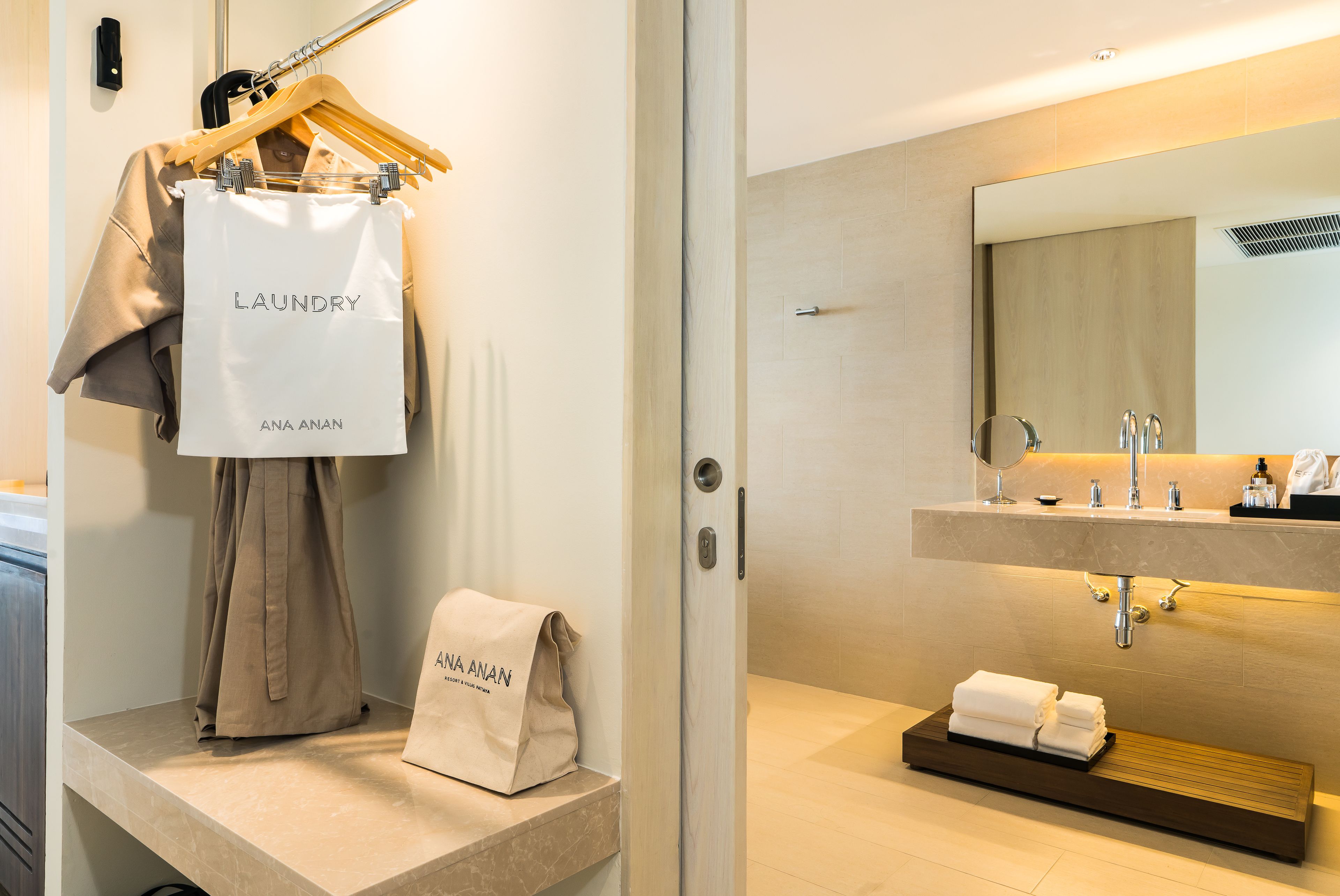 A modern bathroom with a sink, mirror, and towel rack.