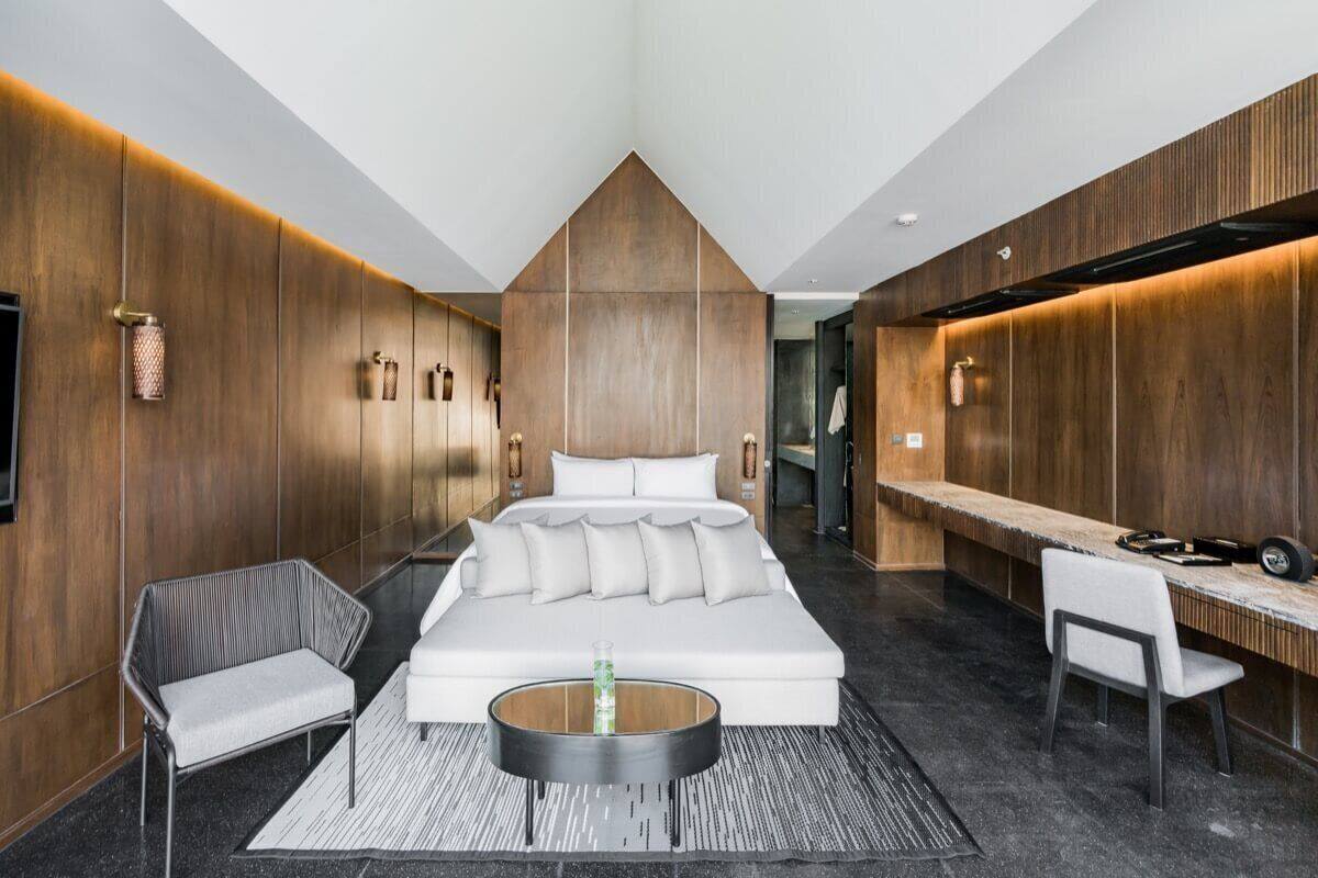 Une chambre d’hôtel moderne dotée d’un grand lit, d’un coin salon et d’un bureau.