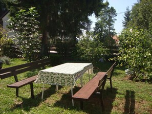 Un espacio al aire libre con mesa y bancos.