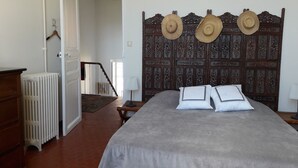 Une chambre à coucher avec un grand lit, une tête de lit en bois et un radiateur.