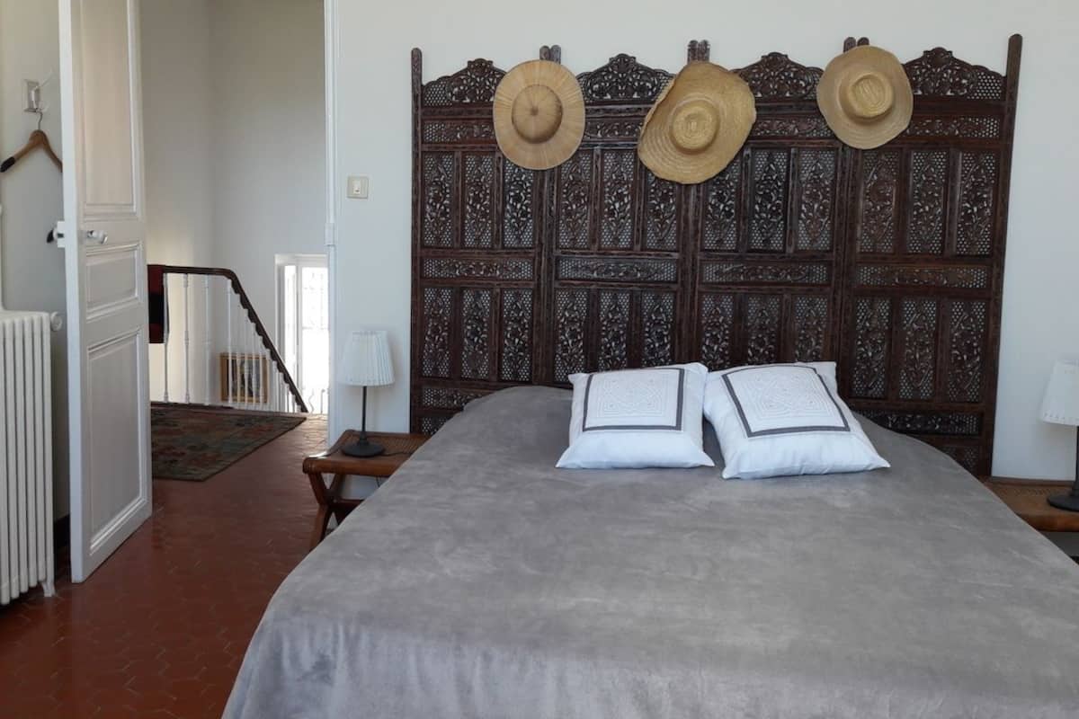 A bedroom with a large bed, a wooden headboard, and a radiator.