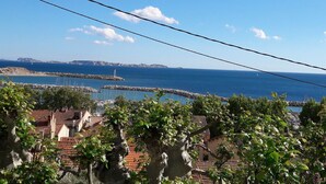 Une vue côtière avec une digue rocheuse, un phare et un port de plaisance.