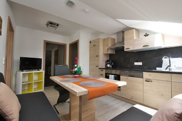 A compact living space with a kitchenette, a dining area, and a seating area.