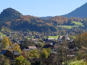 A village with houses, a church, and mountains in the background. - Apartment Waldblick - Apartments Winkler (Bad Goisern am Hallstättersee)