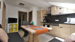 Een knus woongedeelte met een kitchenette, een eethoek en een zithoek.