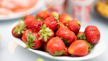 Une assiette blanche remplie de fraises fraîches.