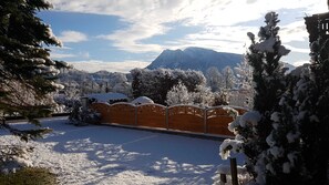 A snow-covered landscape with a wooden fence, trees, and a mountain in the background. - Apartment Sonnenblick - Apartments Winkler (Bad Goisern am Hallstättersee)