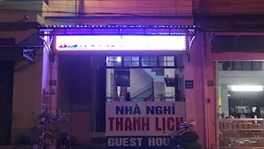 Un immeuble sur lequel on peut lire, en lettres néon, l’inscription « THANH LICH GUEST HOUSE ».