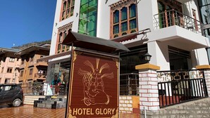 Un hôtel à plusieurs étages, doté d’éléments architecturaux traditionnels et modernes, notamment des balcons et de grandes fenêtres.